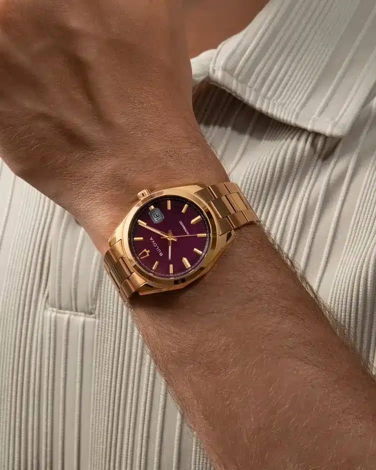 Bulova Surveyor 97B234 al polso, quadrante melanzana e bracciale a tre maglie color oro rosa